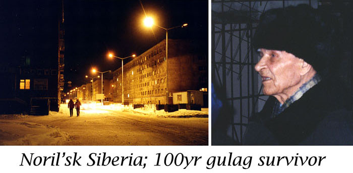 A street with lights and buildings in the background.