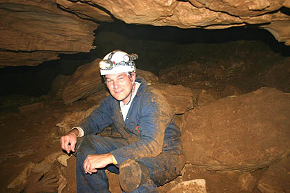 A man sitting in the middle of a cave.