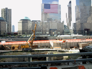 A construction site with a large american flag in the background.
