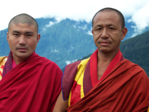 Two monks in red robes standing next to each other.